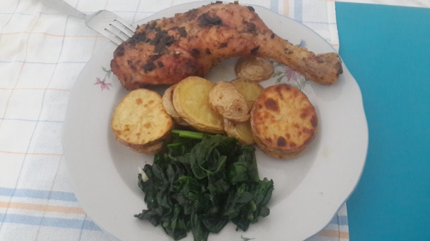 Chicken legs with crispy marinated baked potatoes, and sauteed spinach
